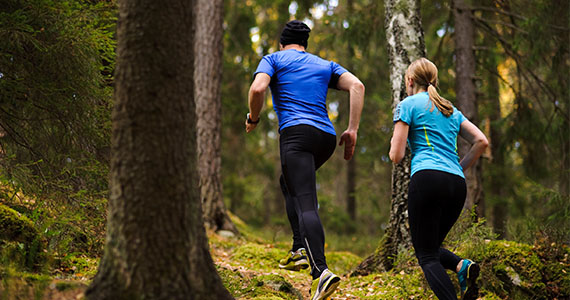 Två personer som joggar i skogen Två personer som joggar i skogen